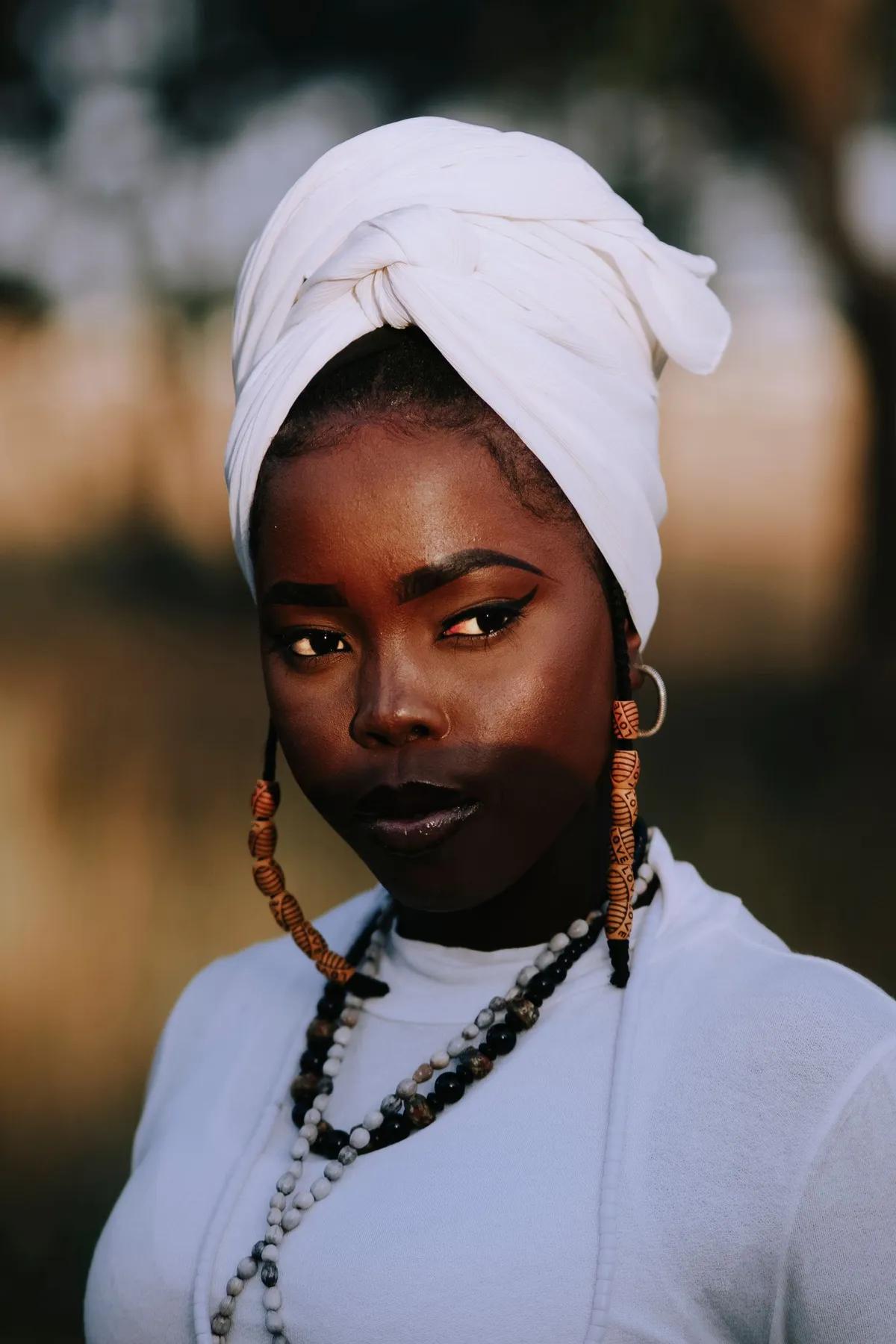 Femme au turban blanc et bijoux ambre